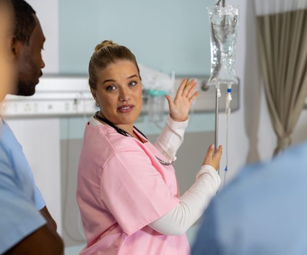 Caucasian female doctor with diverse trainee doctors applying drip at hospital. Hospital, traineeship, medicine, healthcare and work, unaltered.